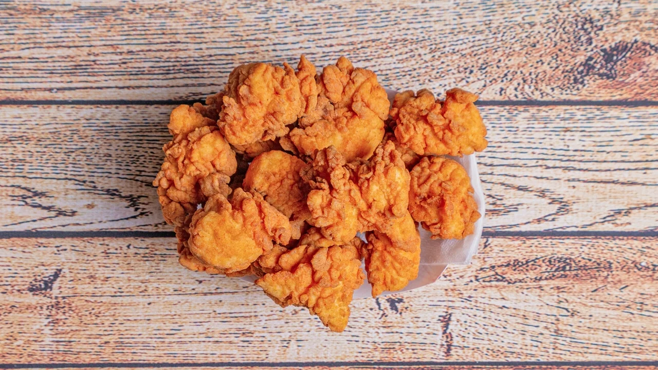 A serving of golden, crispy fried chicken pieces piled high on a tray.
