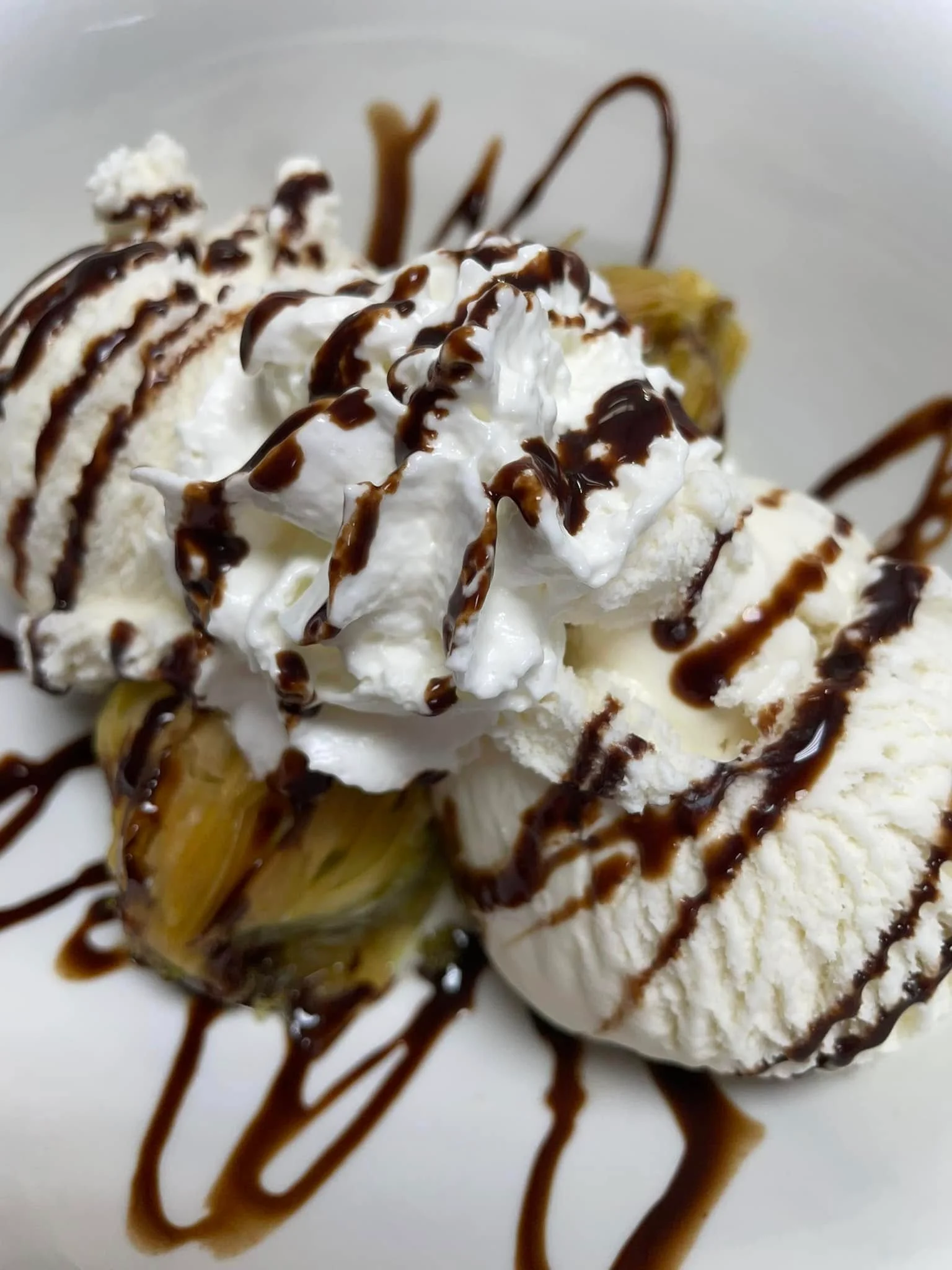 Delicious banana split topped with whipped cream and chocolate sauce