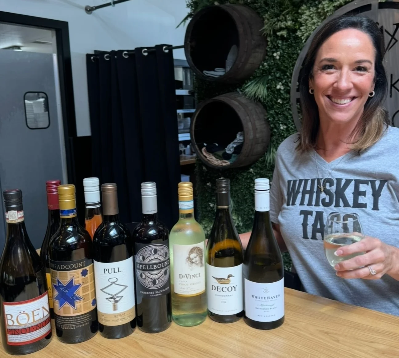 Wine selection displayed at a trendy bar with a smiling bartender