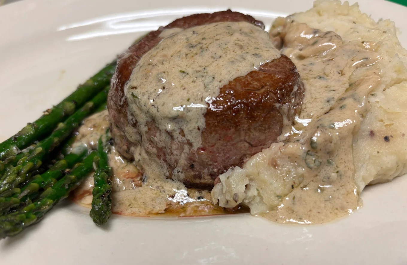 Filet mignon with creamy sauce and asparagus, served with mashed potatoes