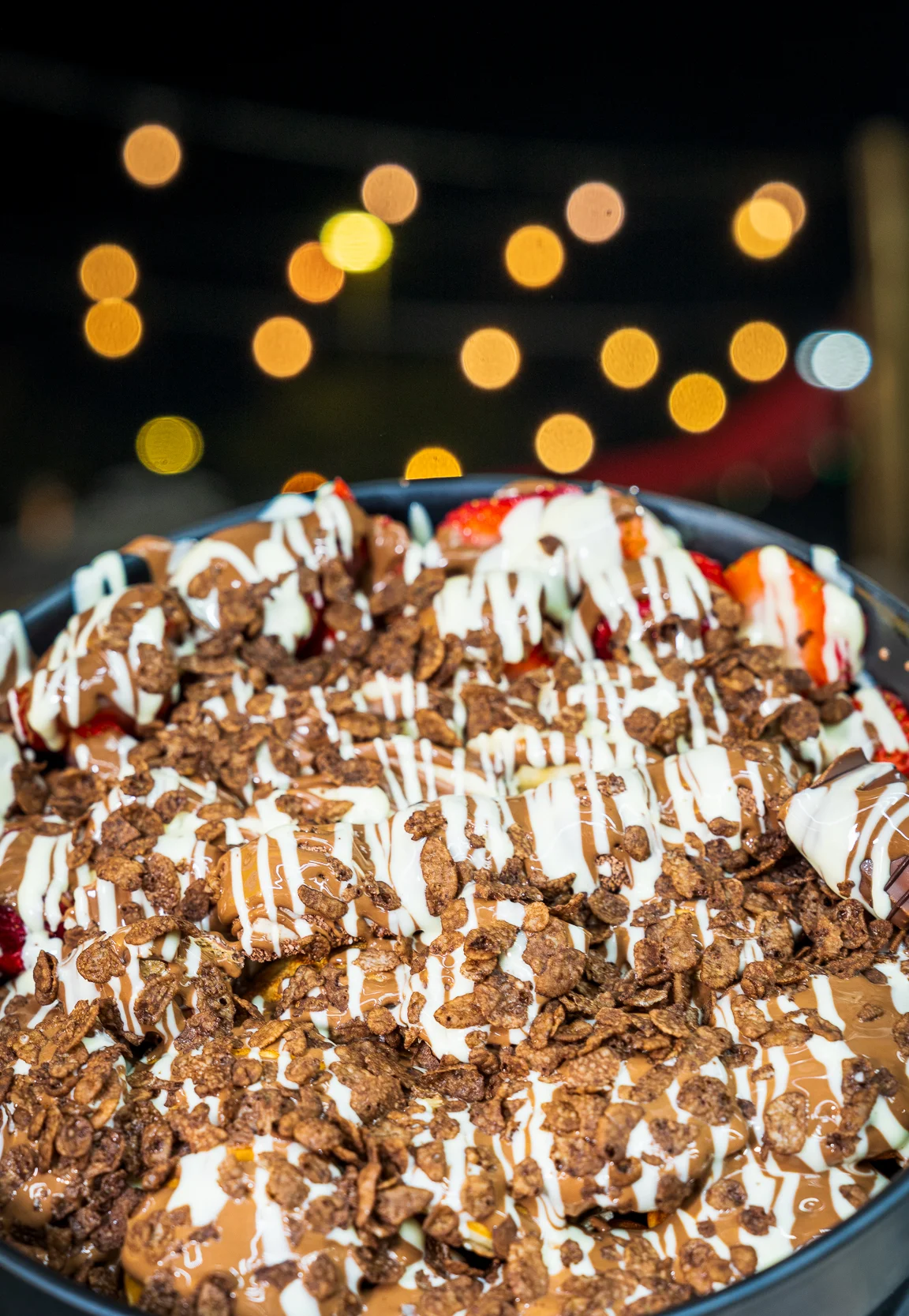 Decadent chocolate dessert bowl with strawberries and drizzled sauces