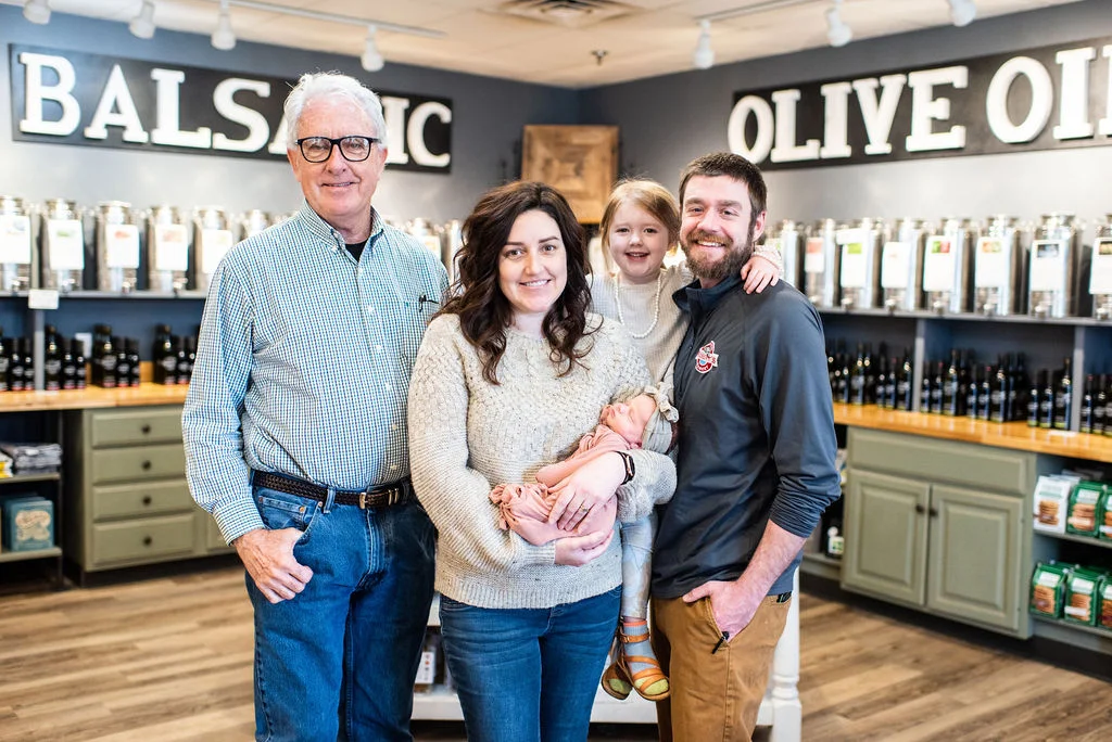 Family portrait in an olive oil shop with balsamic displays