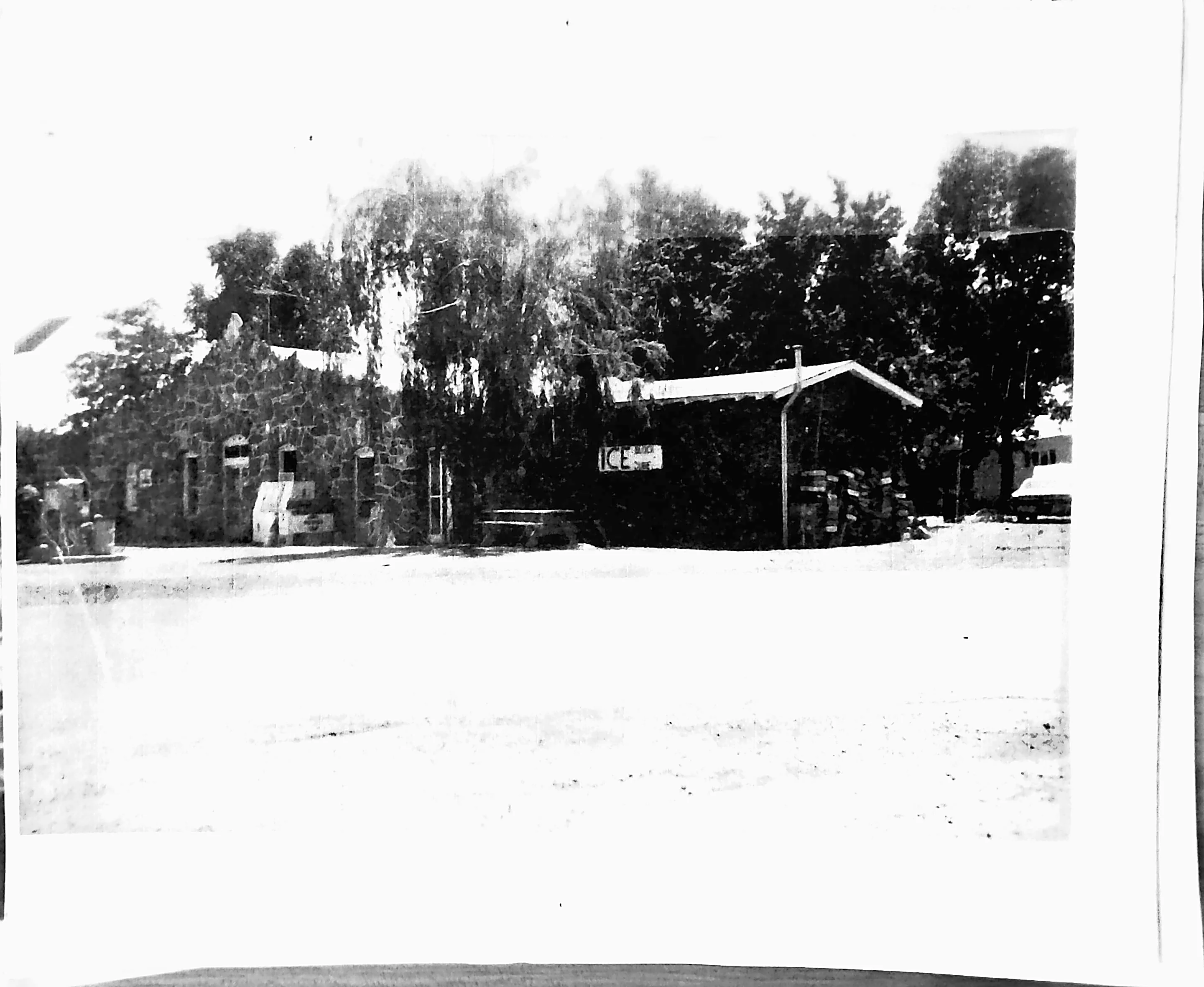 Historic stone building with trees and signage