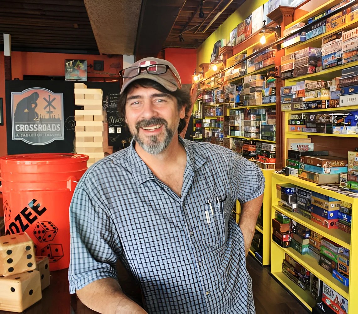 Friendly game store owner in a vibrant board game shop