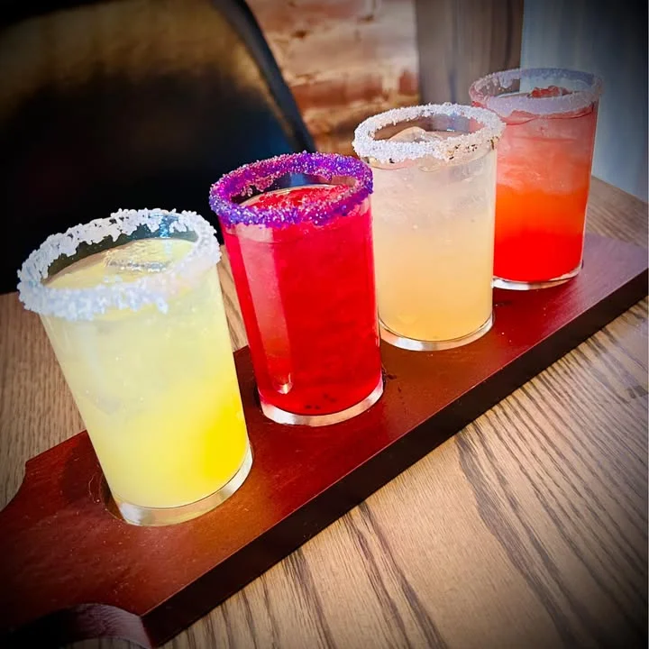Colorful cocktail flight with vibrant drinks and salted rims