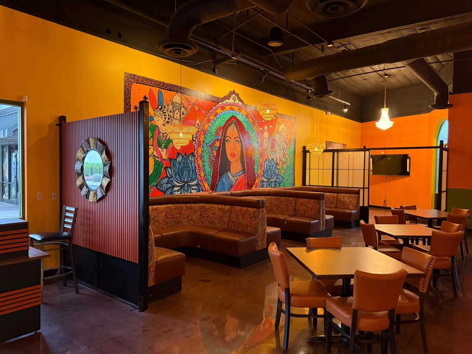Vibrant restaurant interior with colorful mural and cozy seating