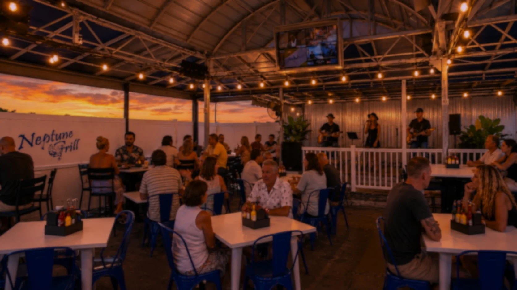 Outdoor dining at Neptune Grill with live music and sunset view