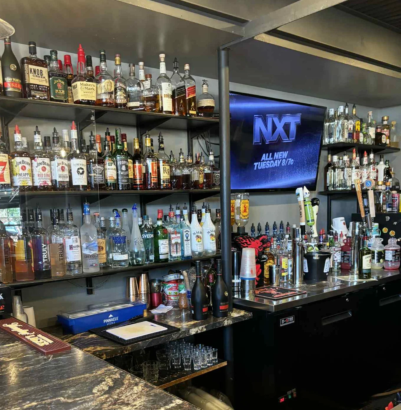 Well-stocked bar with various spirits and cocktails
