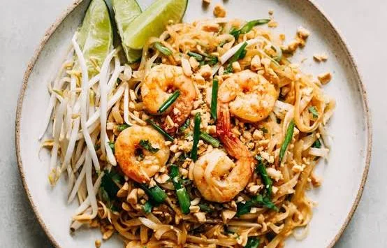 Delicious pad thai with shrimp and lime wedges