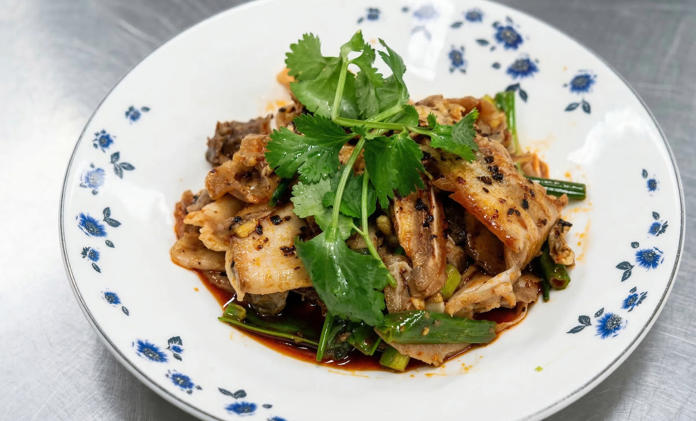 Spicy Sichuan stir-fried noodles with cilantro garnish