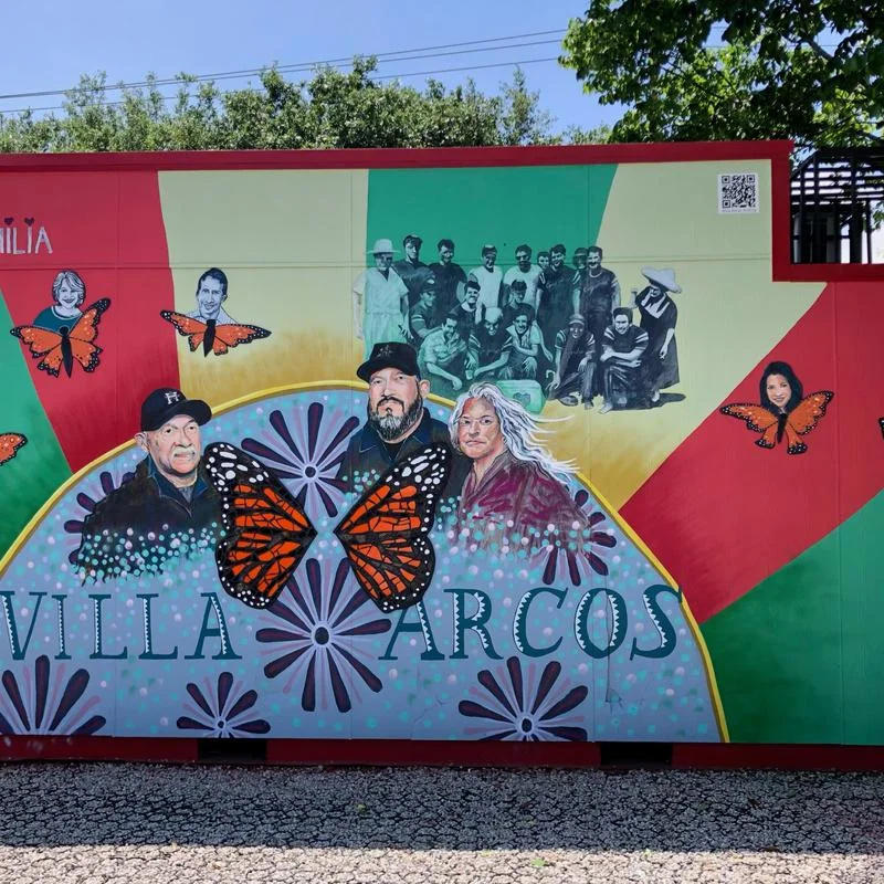 The mural for Villa Arcos featuring multiple generations of families