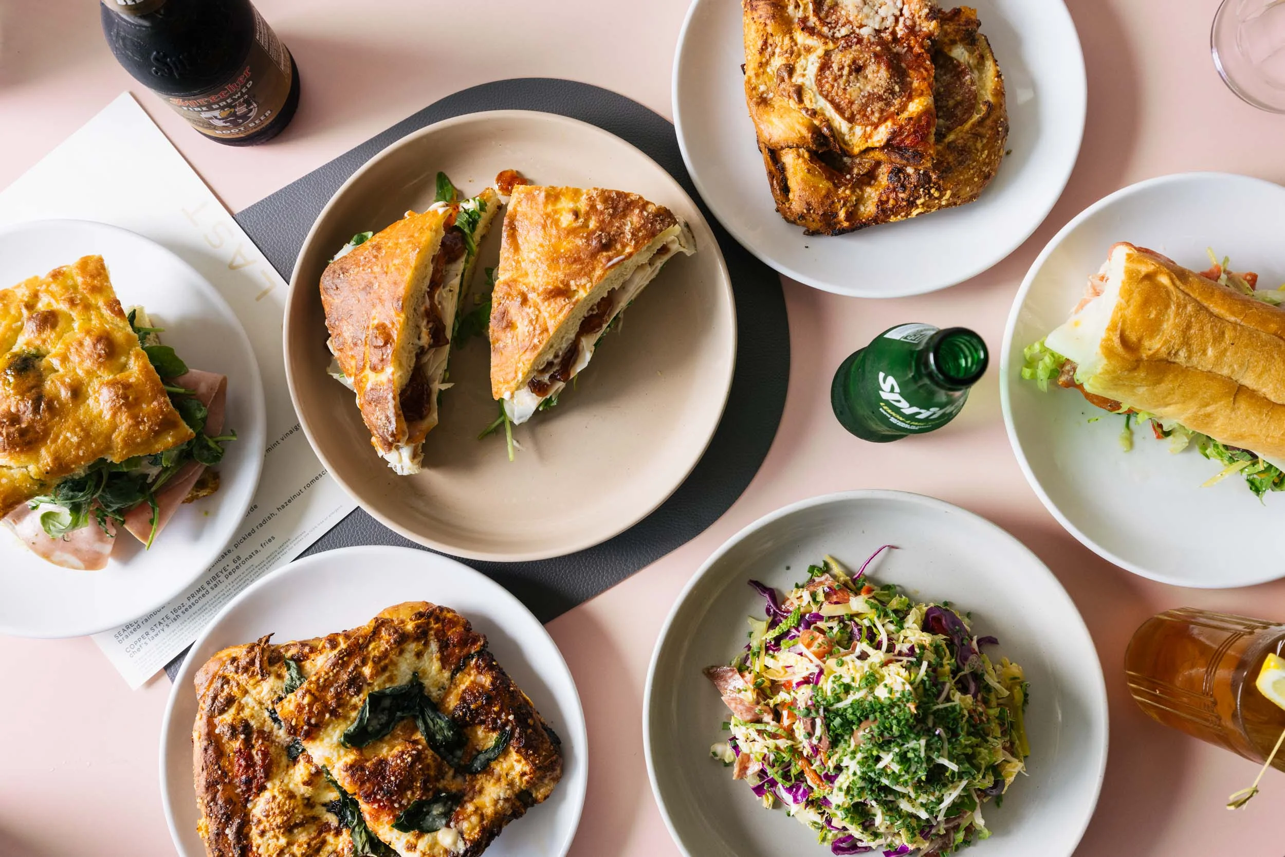 Assorted gourmet sandwiches and salads on a restaurant table