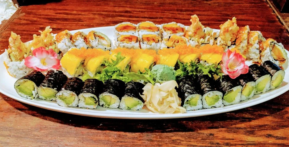 Assorted sushi platter featuring various rolls and garnishes