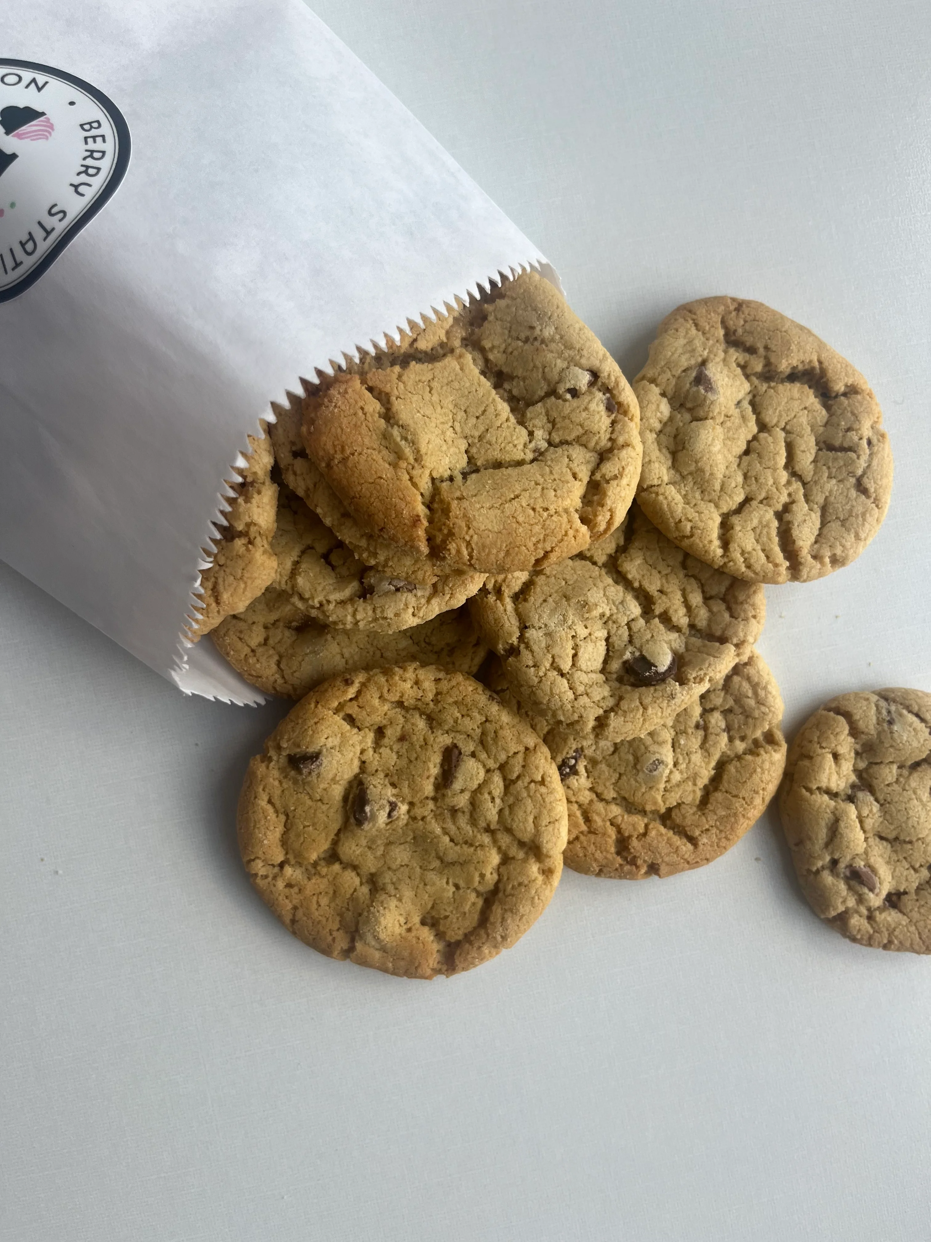 Freshly baked chocolate chip cookies in a paper bag