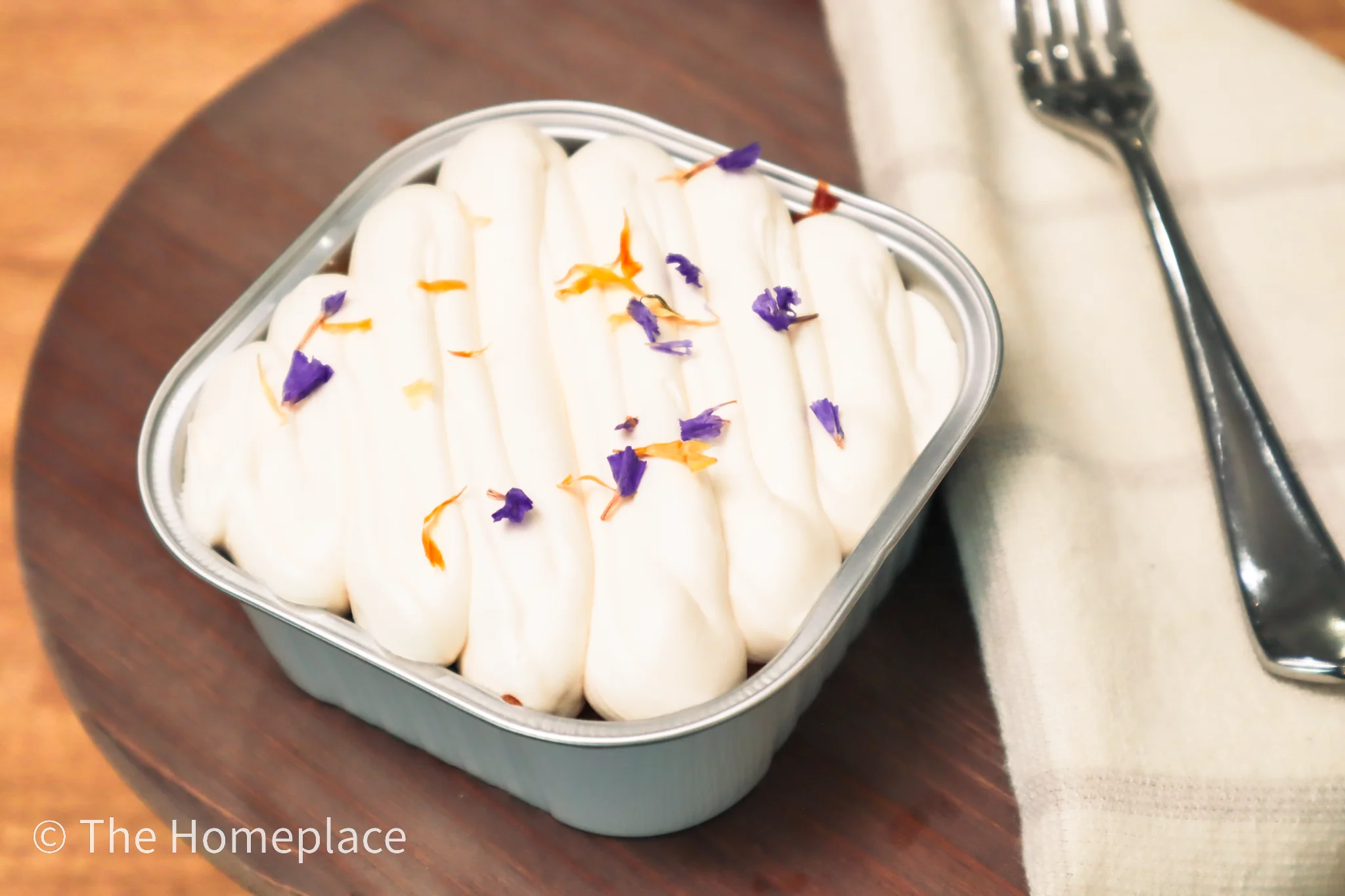 Delicate floral panna cotta dessert in a metal dish