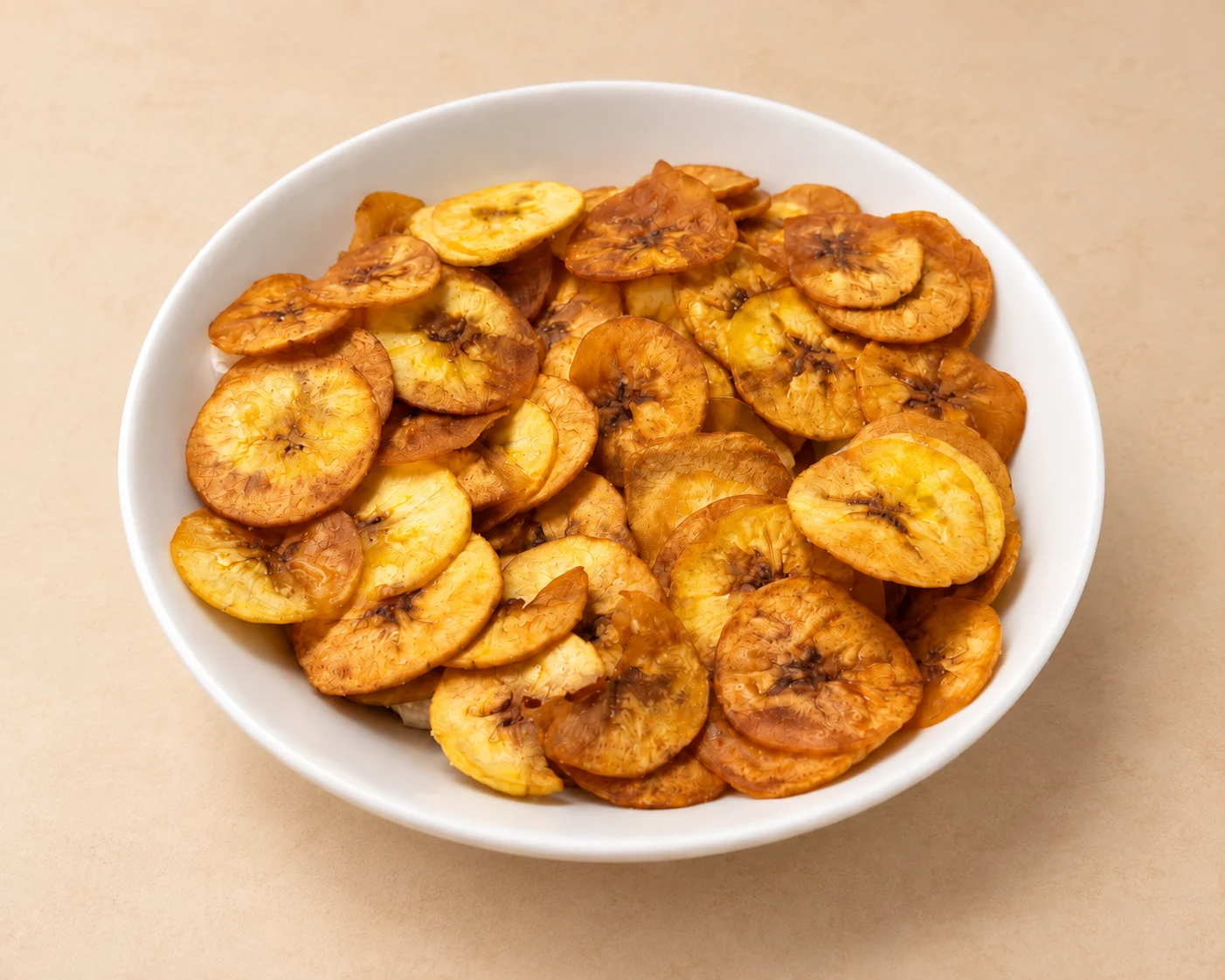 A bowl filled with crispy, golden fried plantain chips.