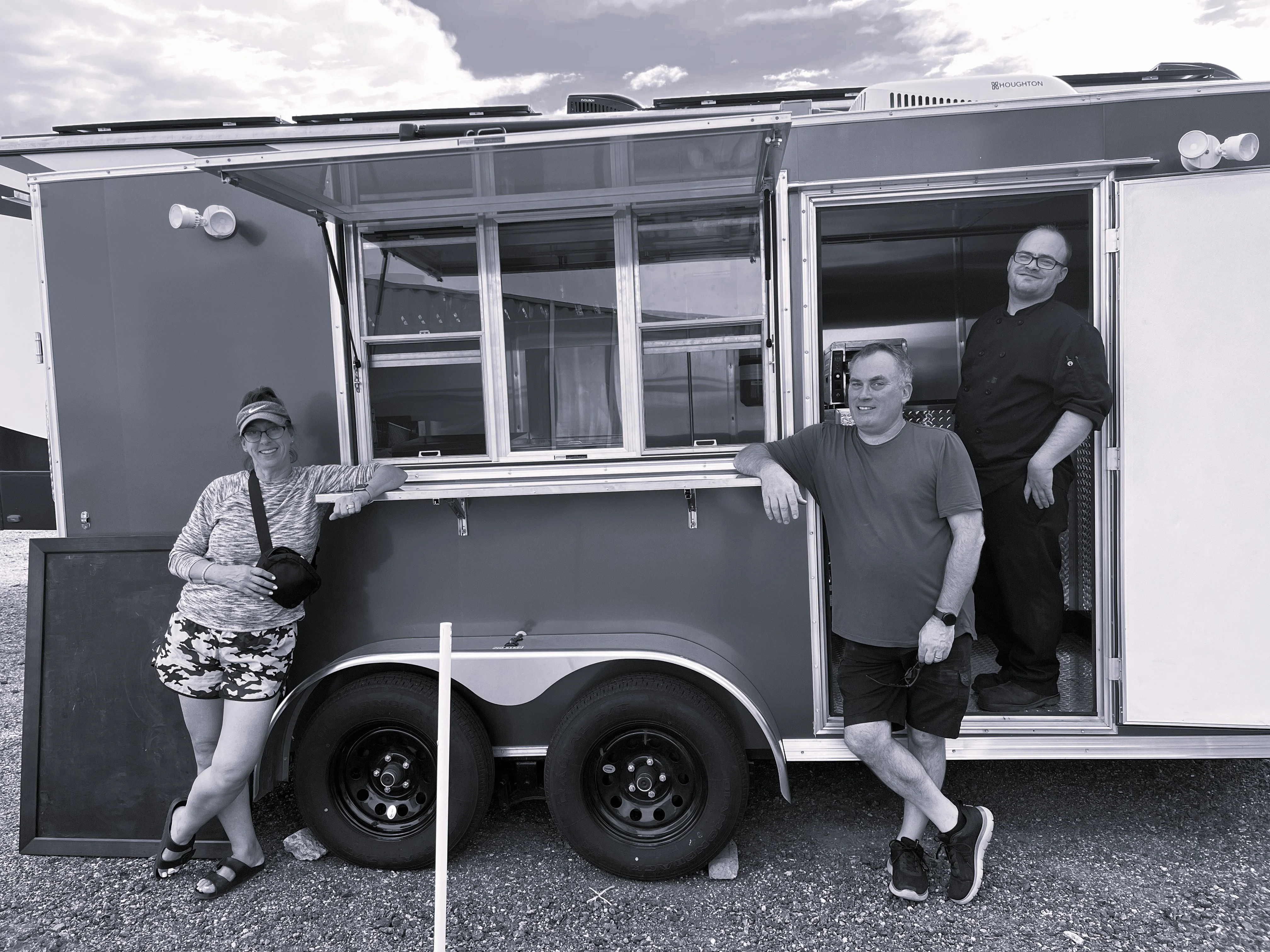 Food truck team posing outside their mobile kitchen
