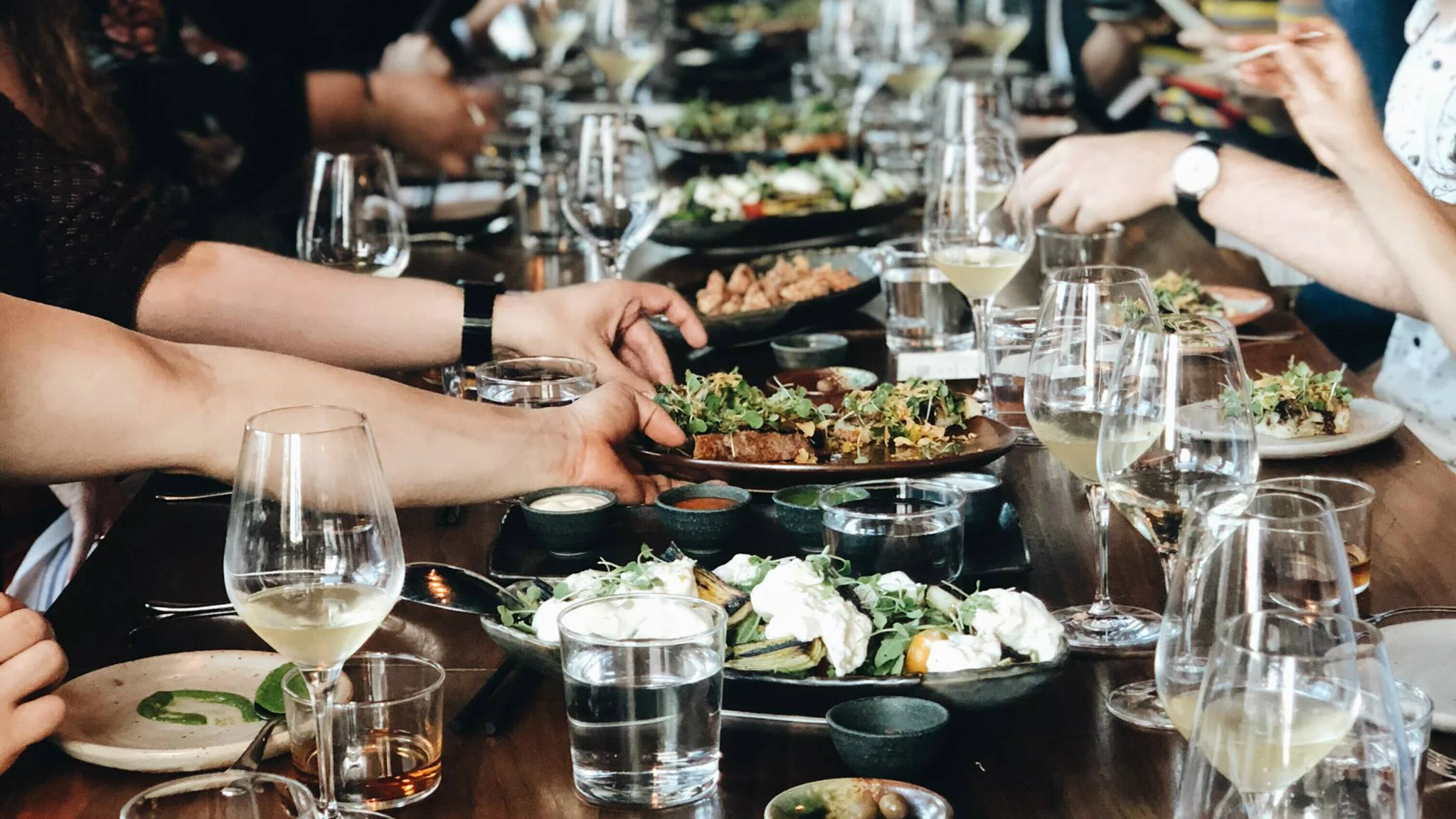 Gathering around a table with shared plates of modern American cuisine