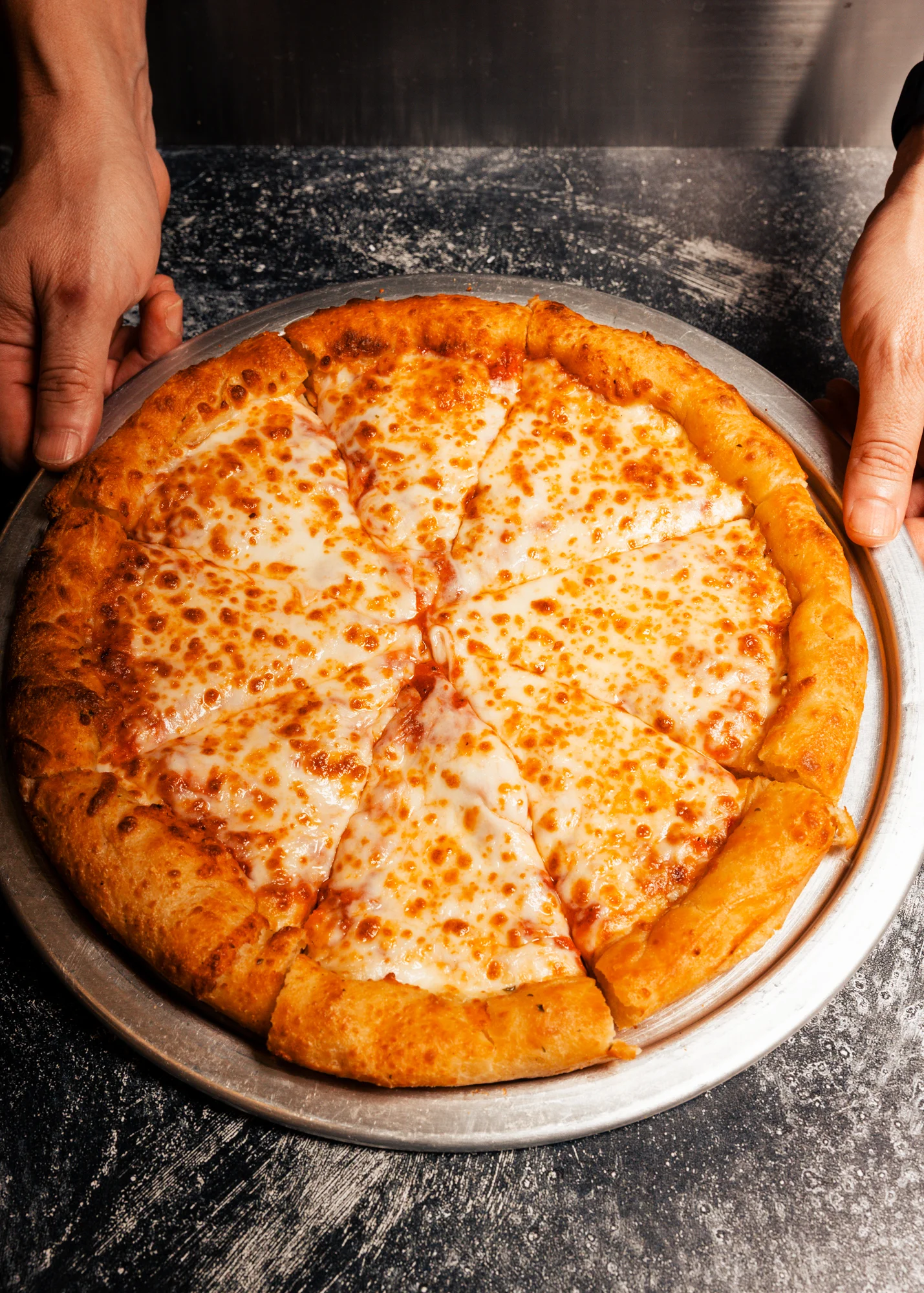 Cheese pizza on a metal tray, freshly baked and ready to serve