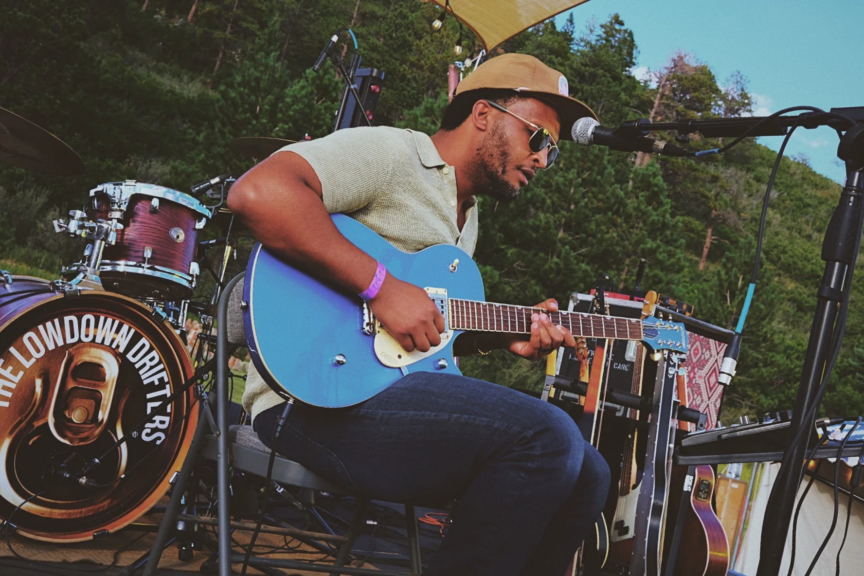 Musician performing live with a blue guitar on stage