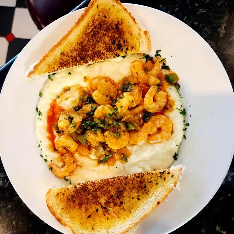 Creamy shrimp and grits topped with sautéed shrimp and peppers, served with Texas toast at Moonlite Diner.