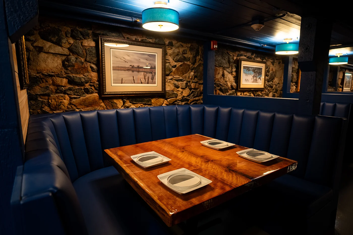 Cozy restaurant booth with wooden table and stone wall decor