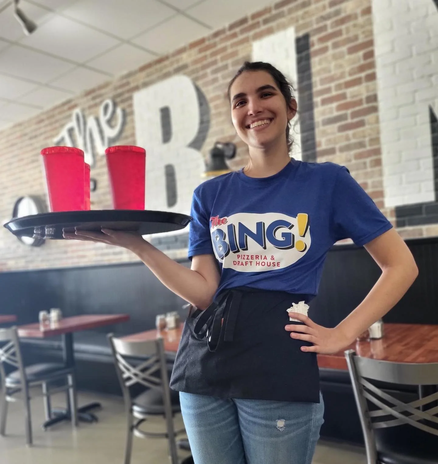 Smiling employee at The Bing Pizza in League City