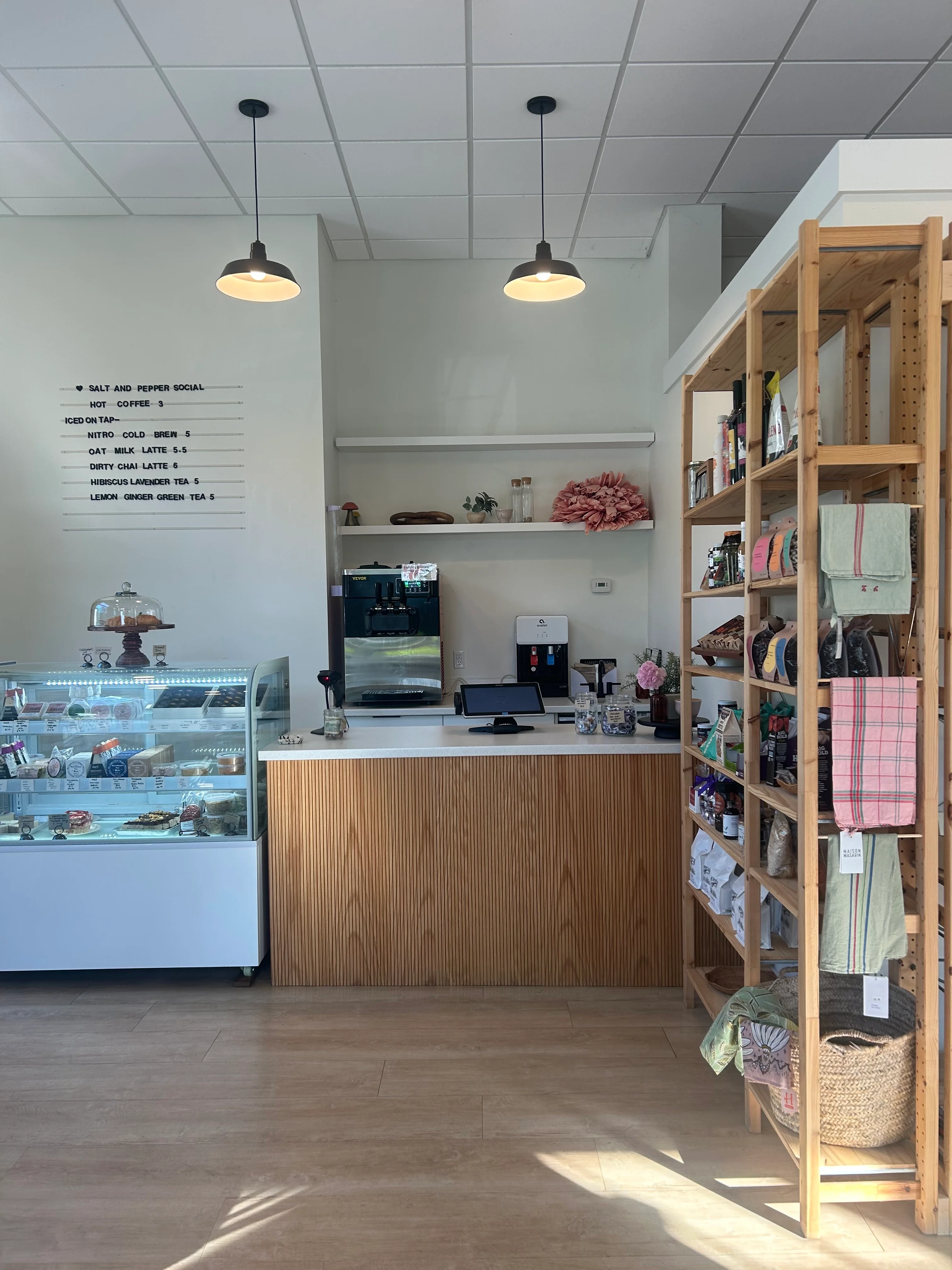 Cozy café interior with a display case and wooden shelving