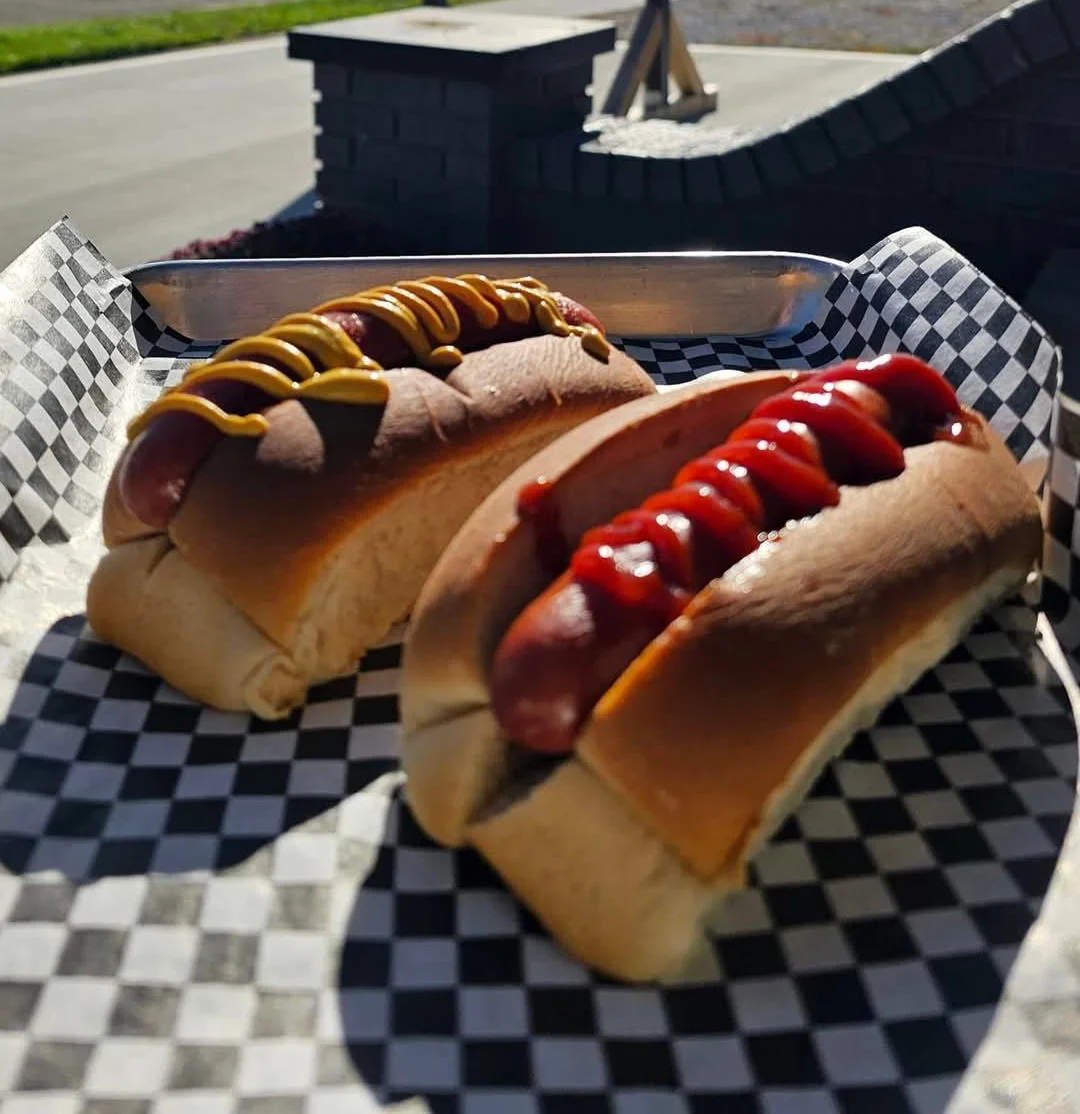 A variety of delicious hot dogs served with toppings on a wooden platter.