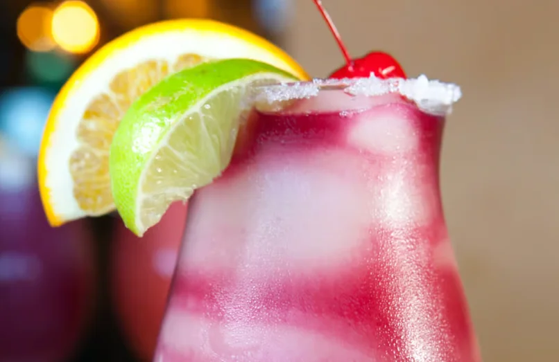 Colorful tropical cocktails and a shrimp salad in a vibrant restaurant setting