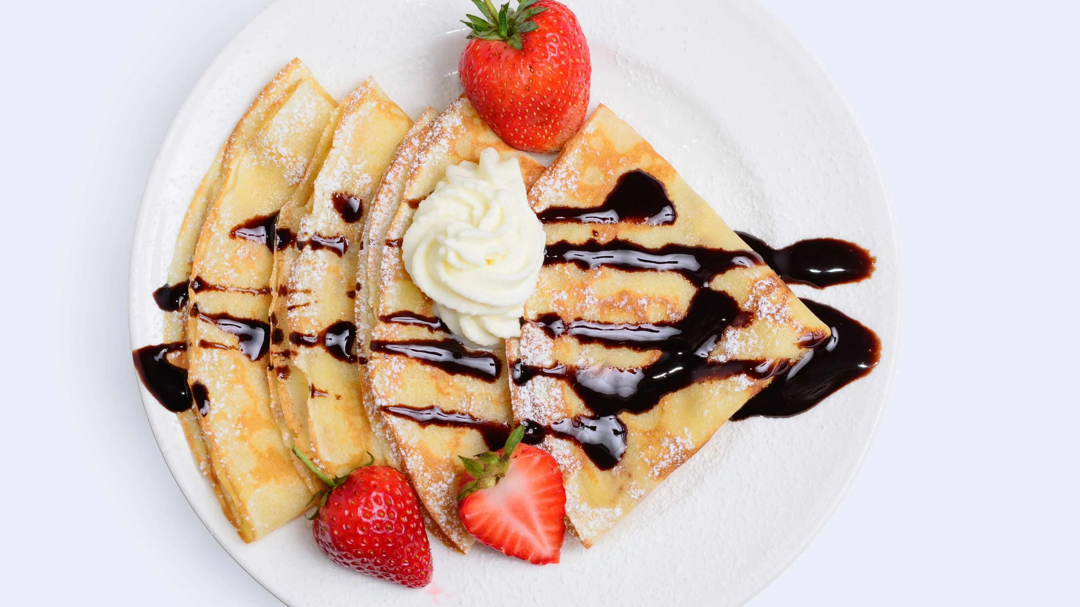 Delicious French crepes with chocolate sauce and strawberries