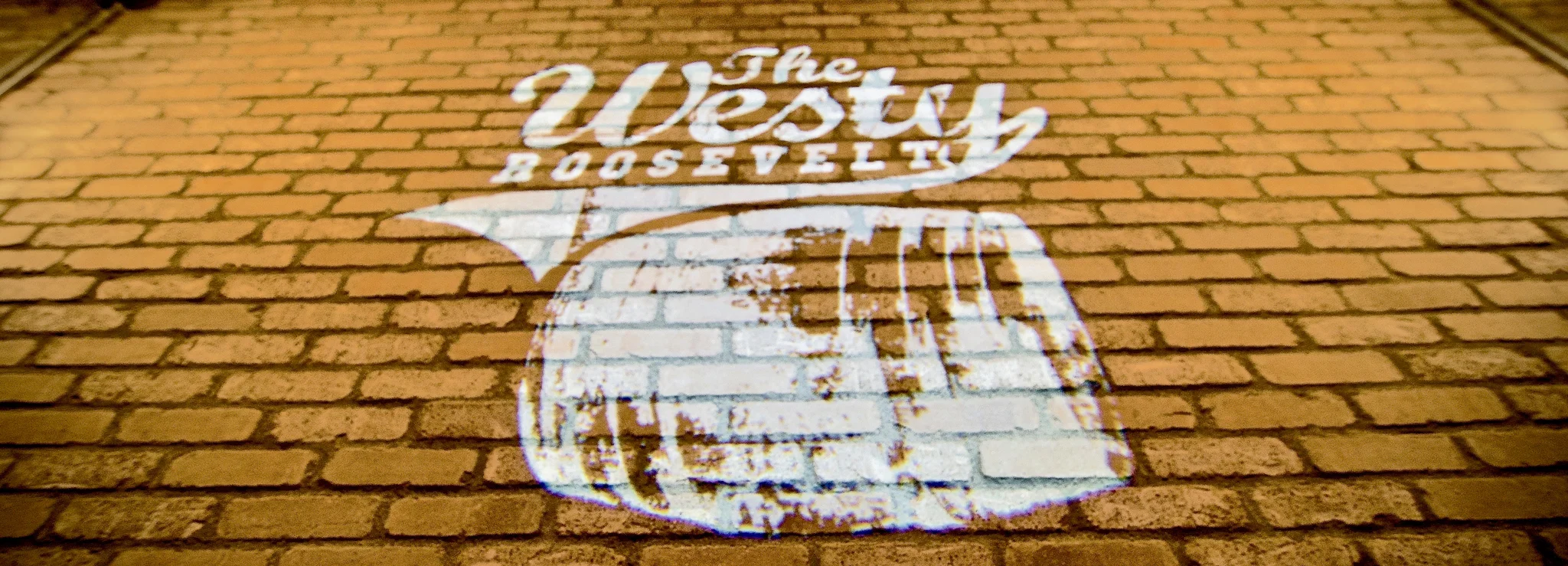 The Westy Roosevelt logo on a brick wall
