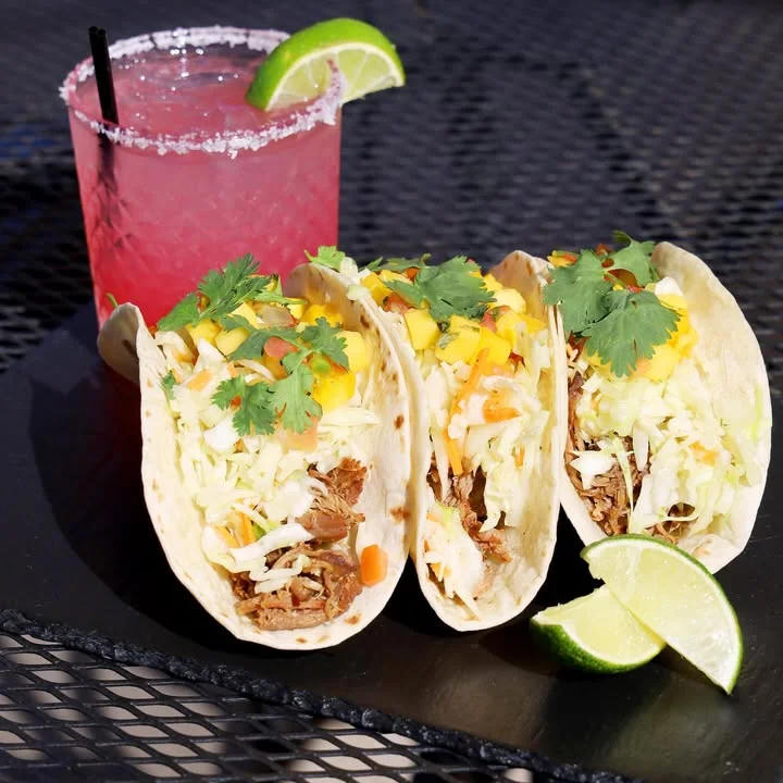 Three delicious tacos with pulled pork and fresh toppings