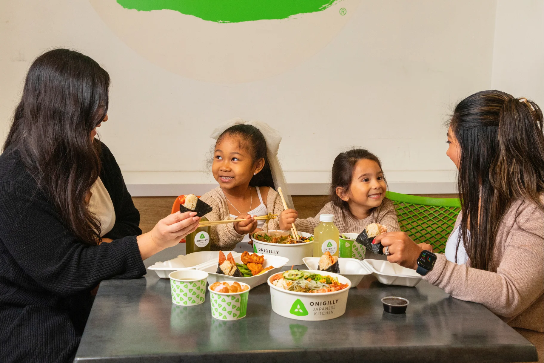 Family enjoying Japanese onigiri and rice bowls at a restaurant