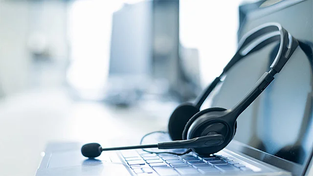 Headset resting on a laptop keyboard in a modern office setting