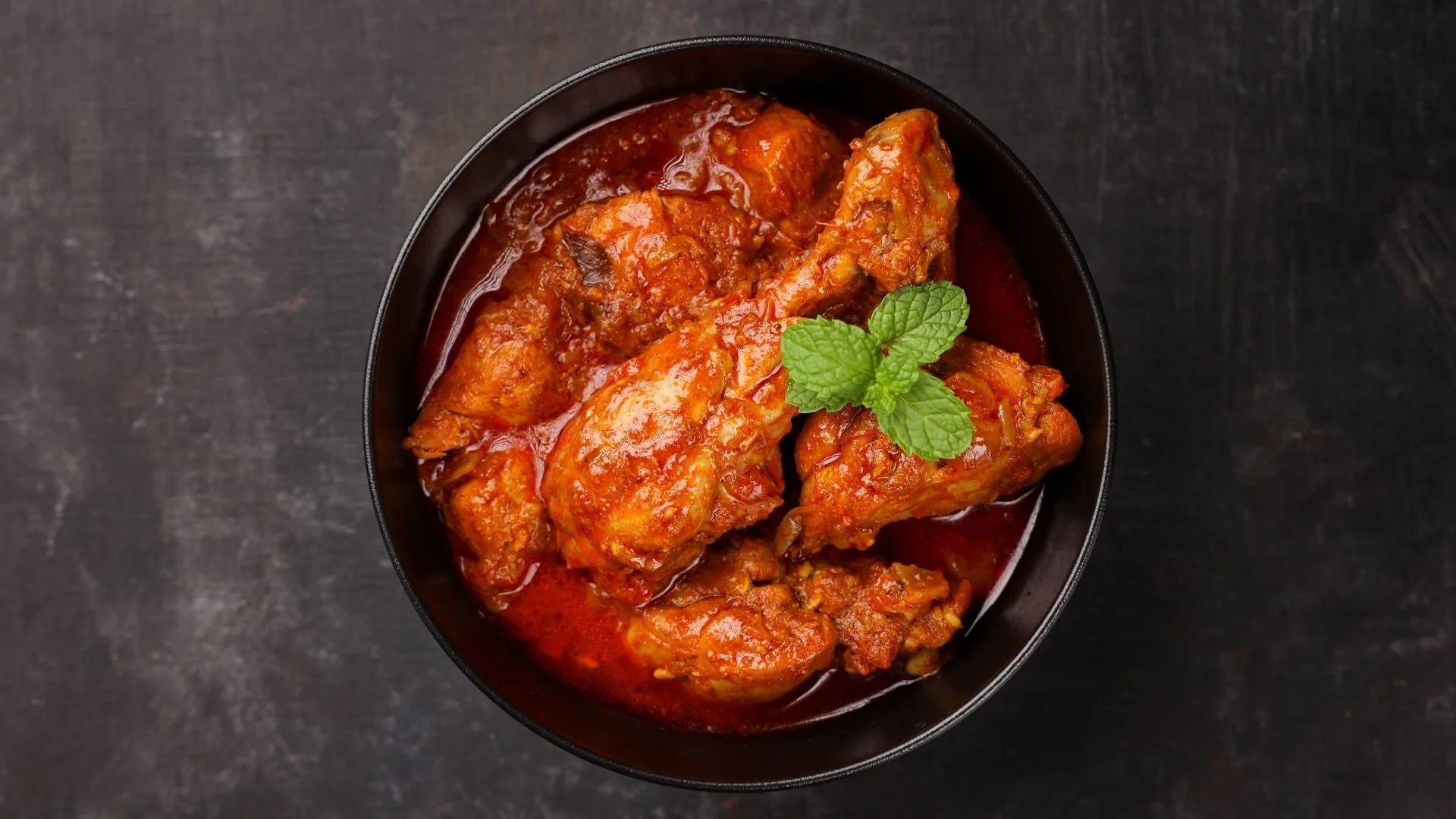 Spicy Indian chicken curry garnished with mint leaves