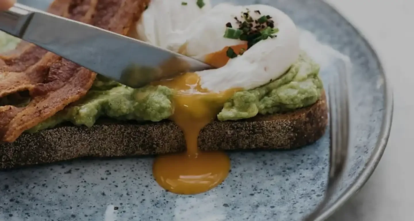 Avocado toast with poached eggs and crispy bacon