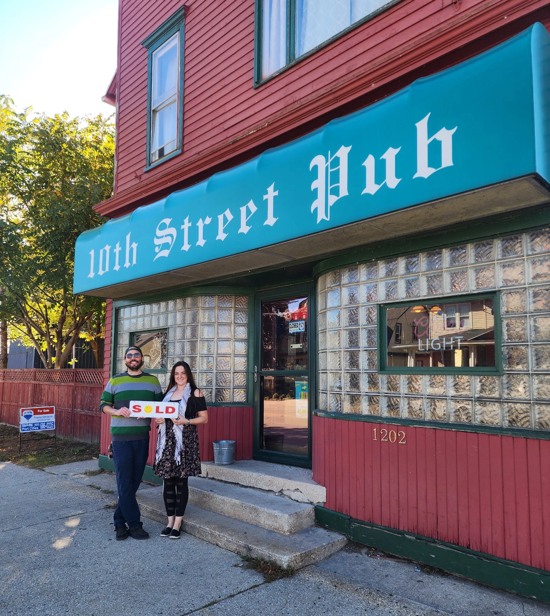 Exterior of 10th Street Pub with sold sign and new owners