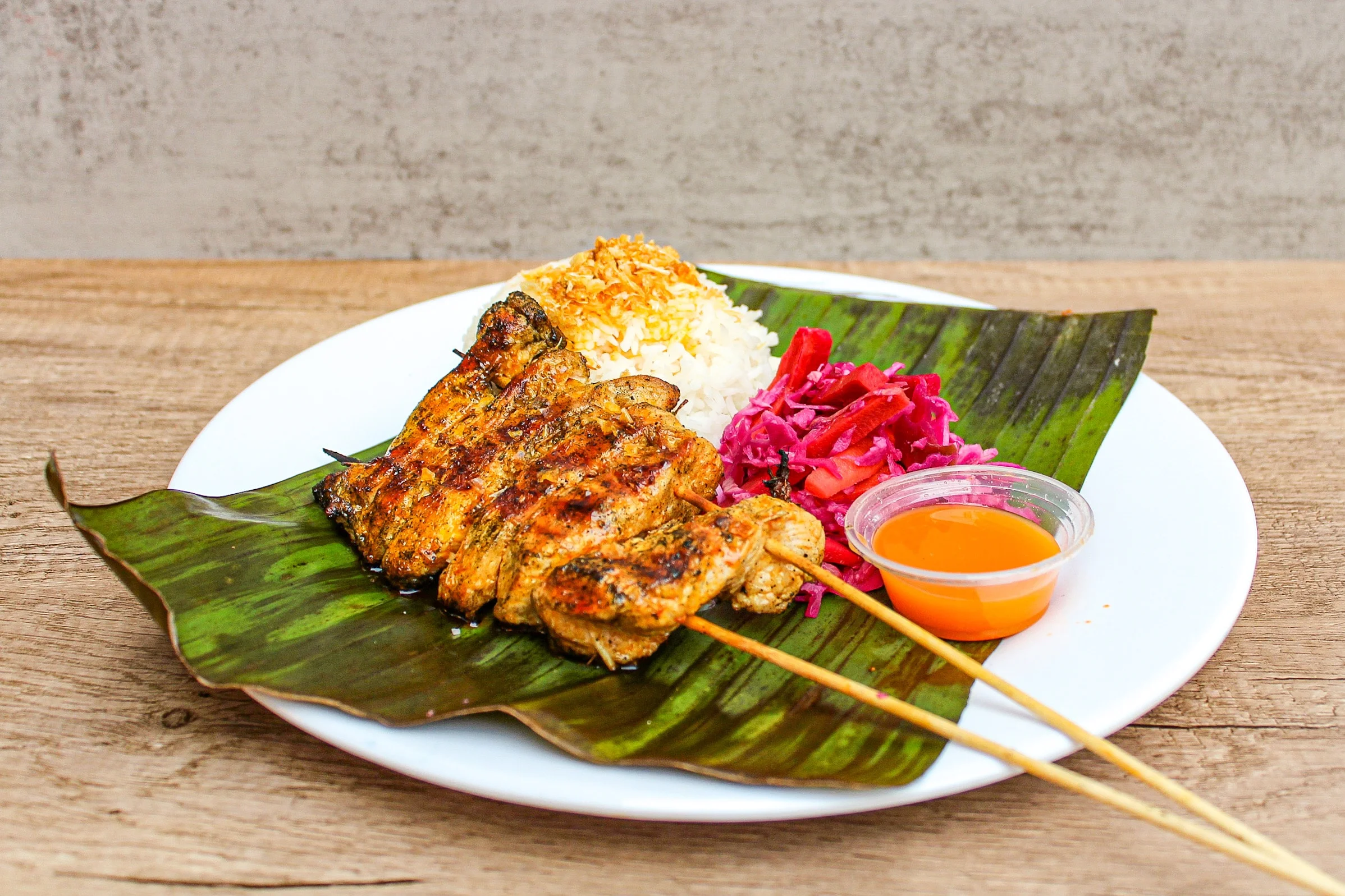 Filipino chicken skewer served with rice and pickled cabbage