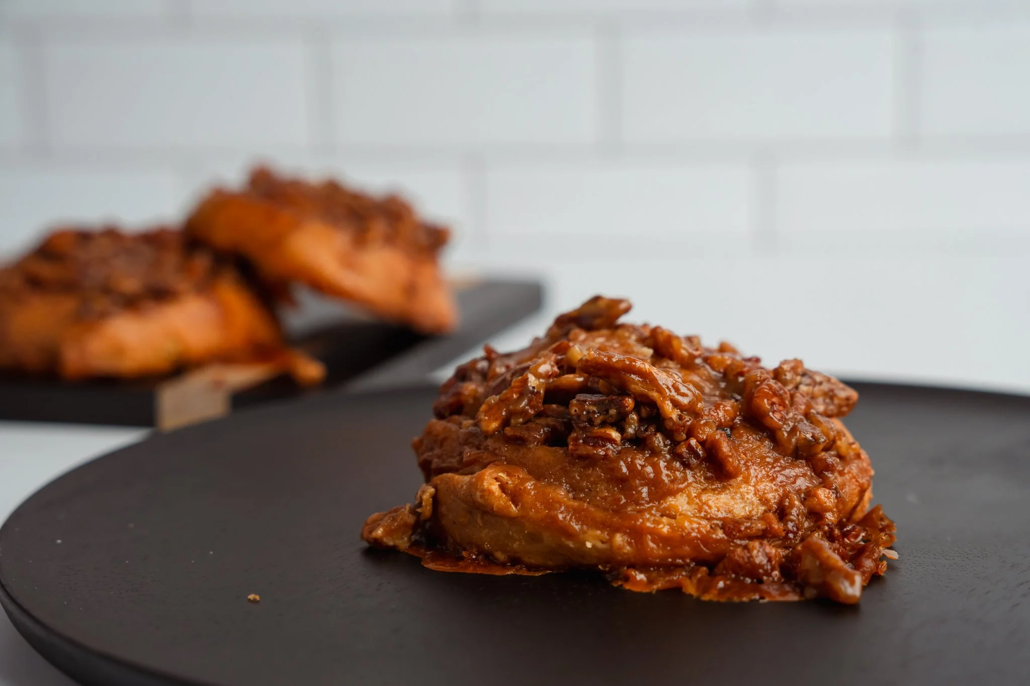 Pecan sticky bun on a black plate