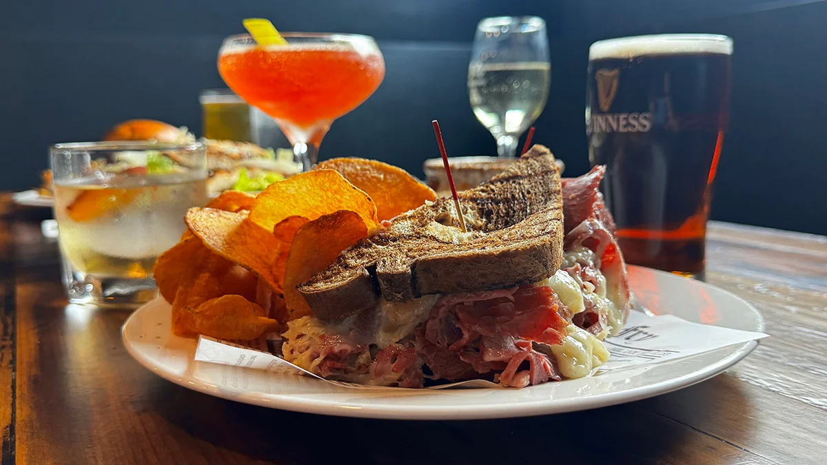 Classic Reuben sandwich with crispy chips and cocktails