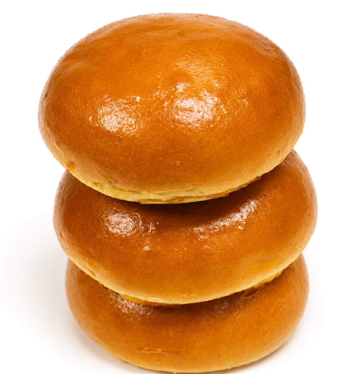 Three golden, shiny bread rolls stacked on top of each other.