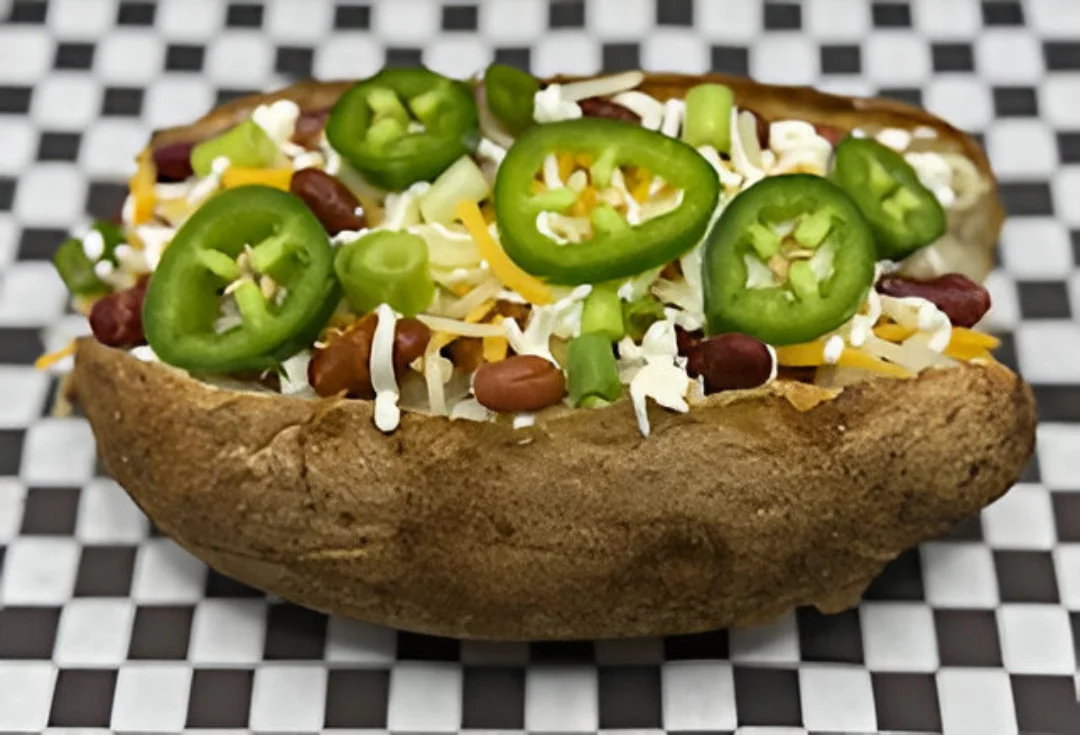 A loaded baked potato with Mexican cuisine toppings