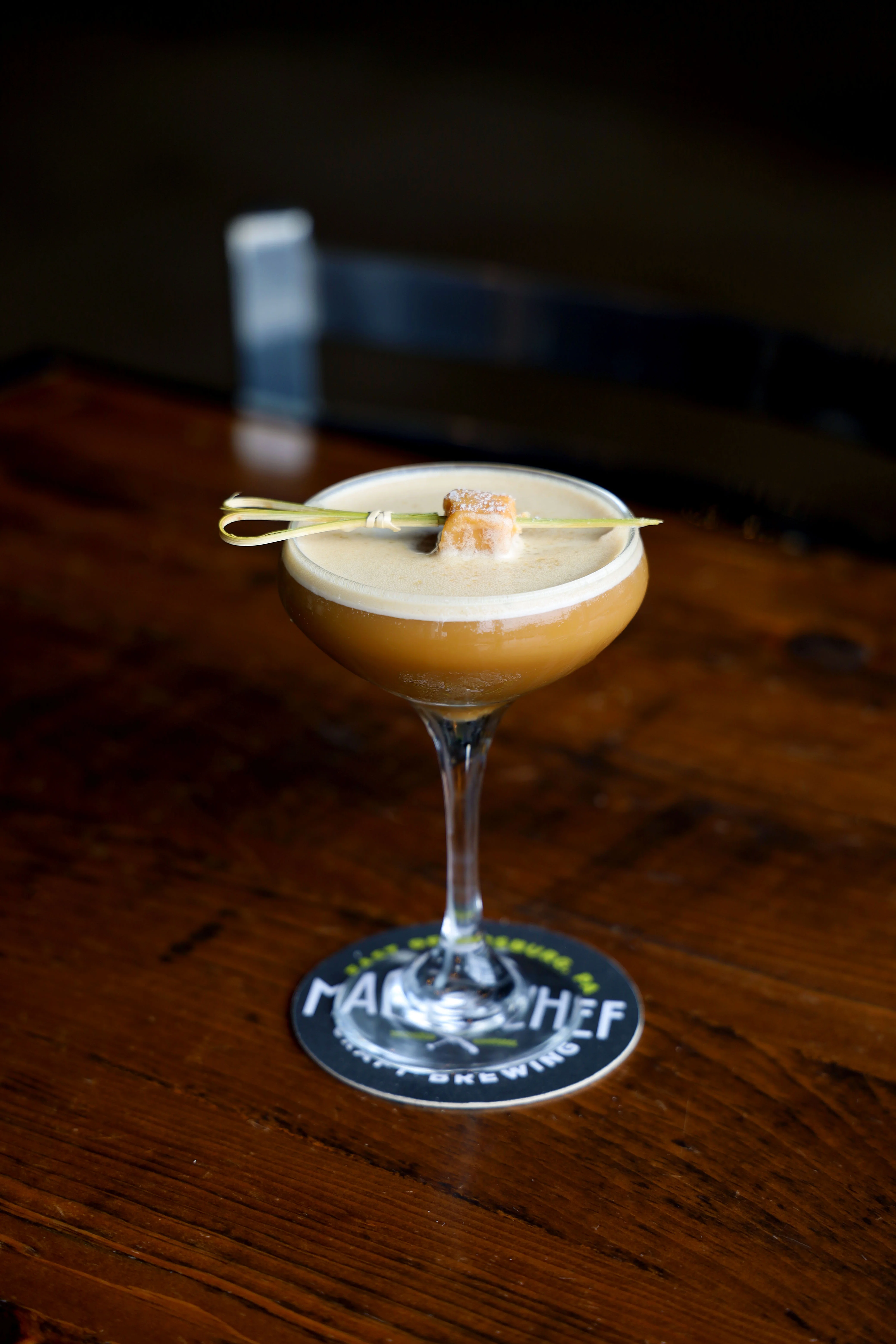 Craft cocktail served in a coupe glass with a unique garnish