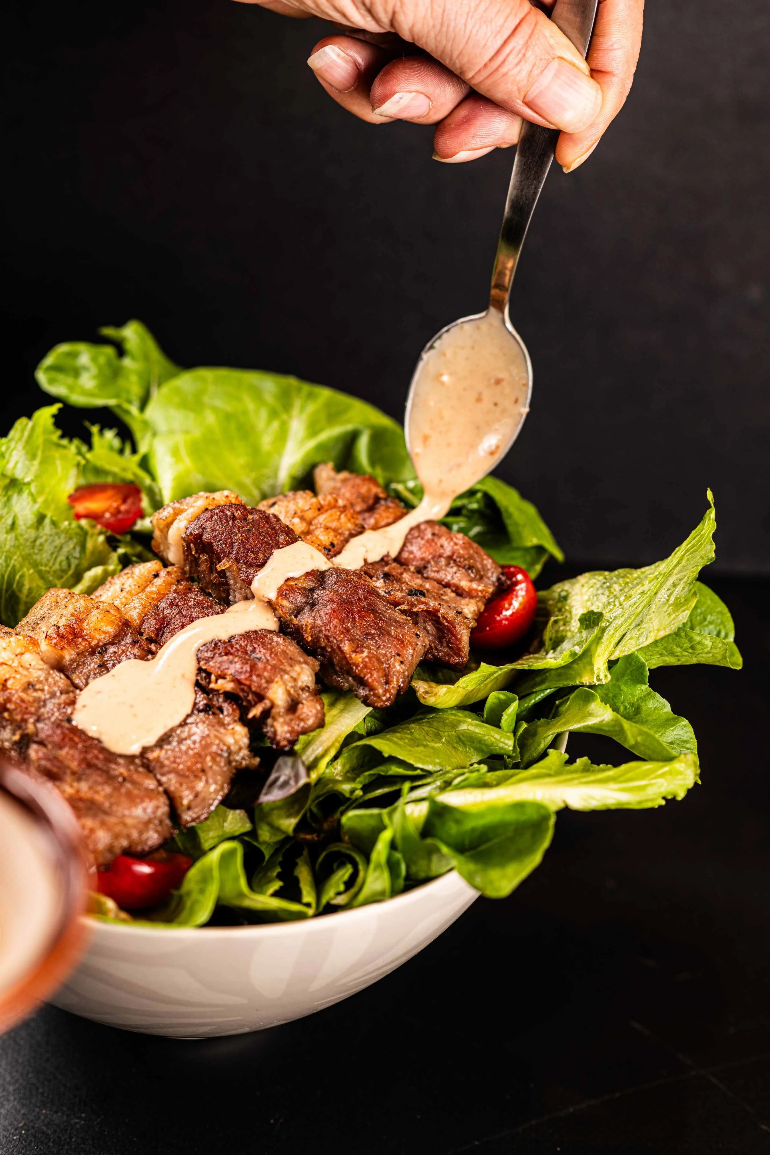 Delicious Filipino sisig salad topped with creamy dressing