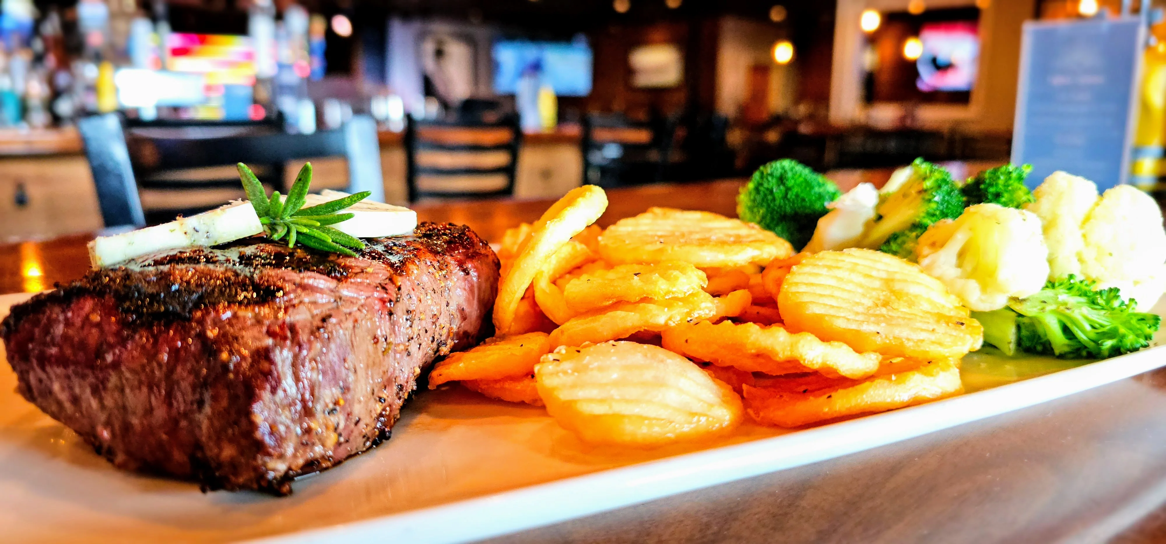 Grilled steak with crispy potato chips and steamed vegetables