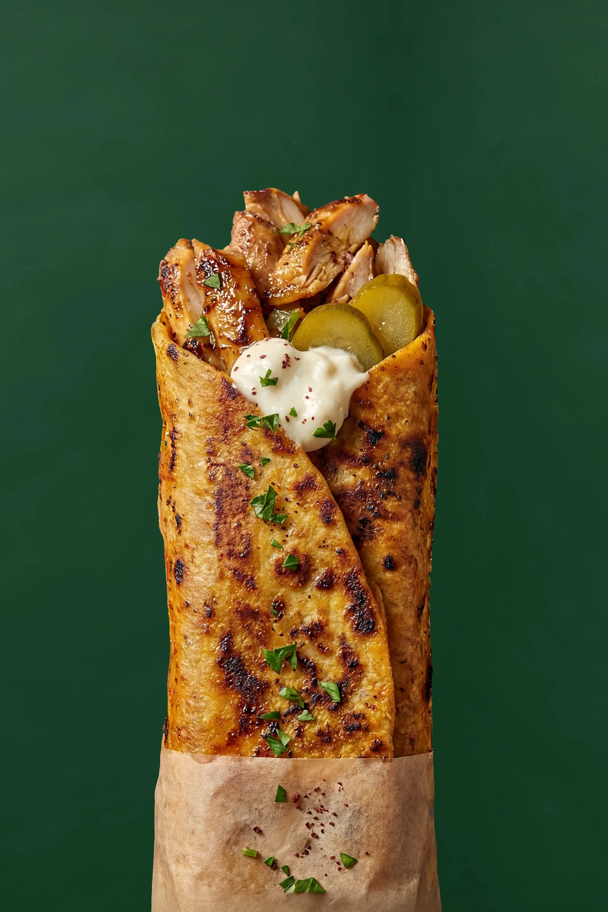 A savory wrap filled with grilled chicken, pickles, and a creamy sauce, wrapped in a toasted flatbread.