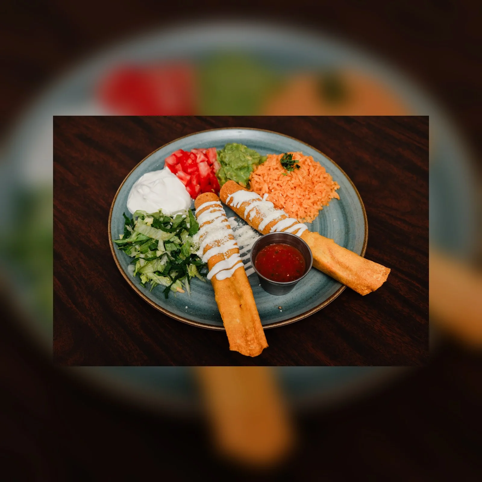 Plate of Mexican flautas with rice, guacamole, and salsa