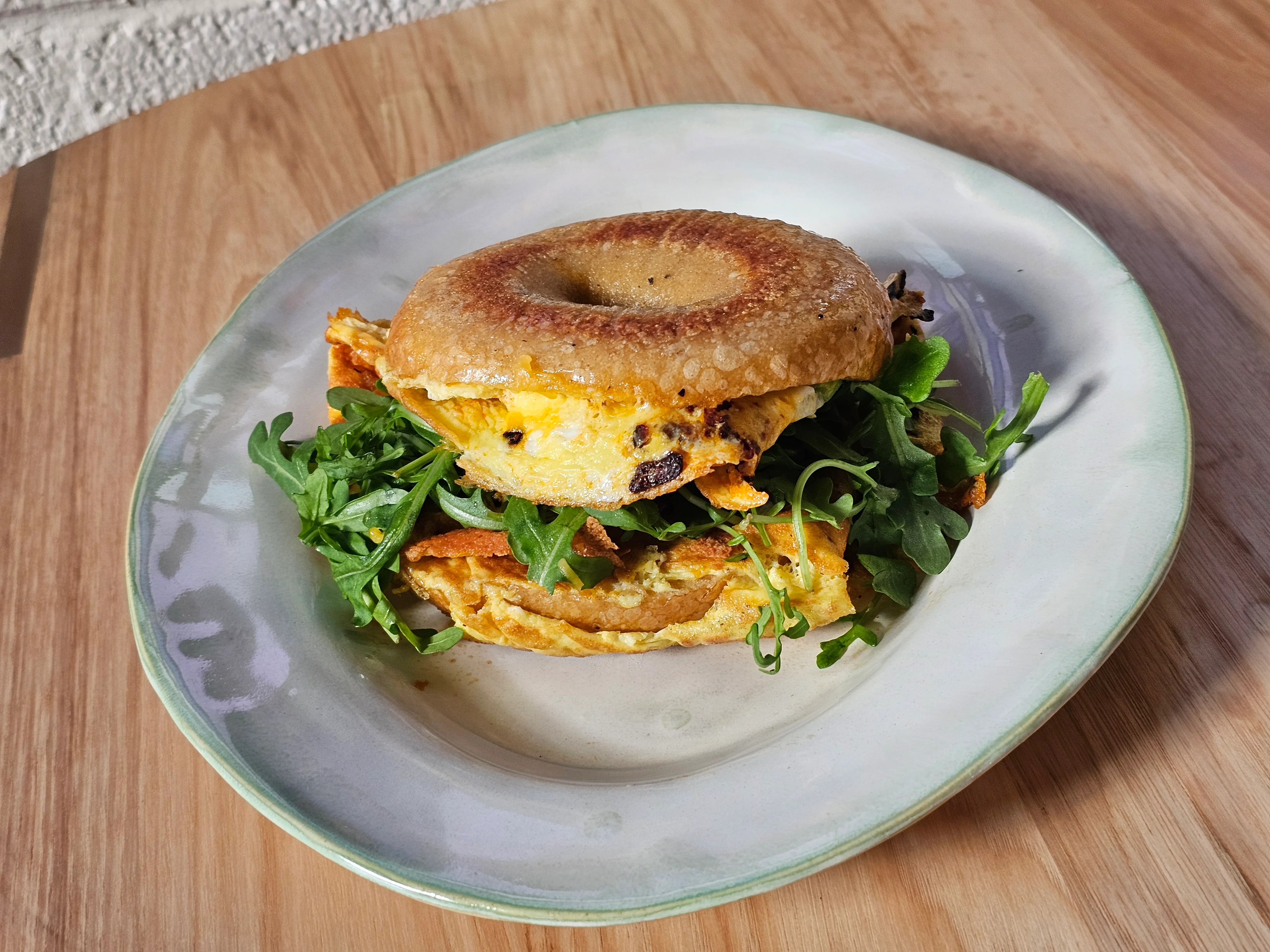 Bagel sandwich with scrambled eggs and arugula