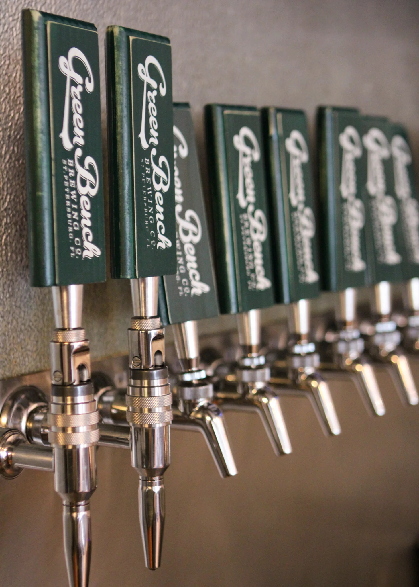 Close-up of beer taps with branded handles at a brewery.